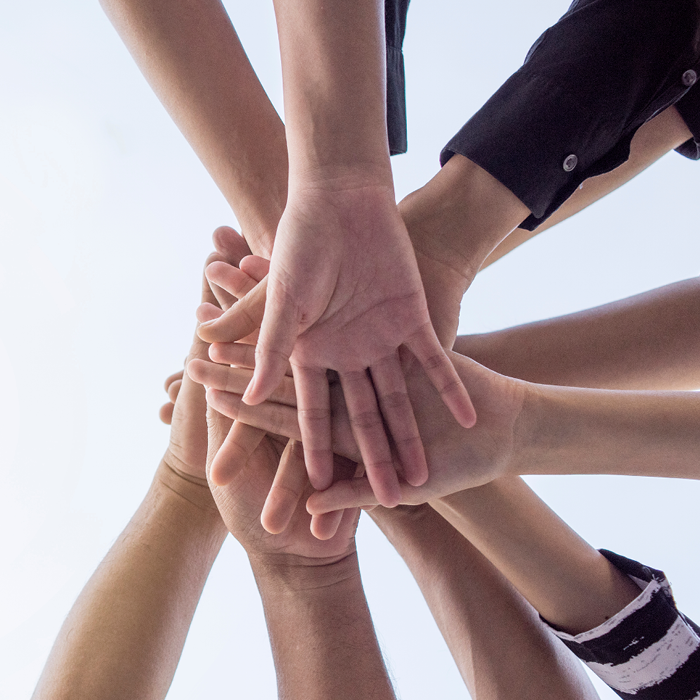 Image of people's hands together in a huddle