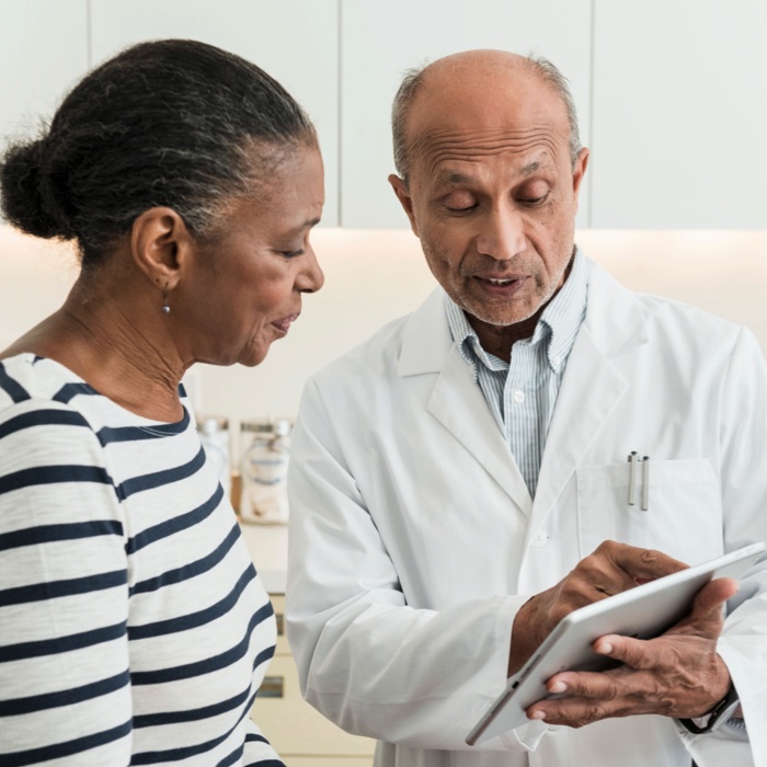Image of a doctor showing a patient information on an ipad. Patient resources. Show more.